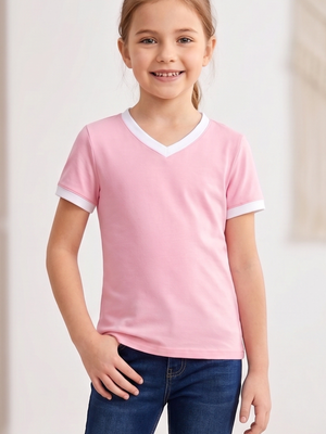 A young girl smiling and wearing a light pink ringer t-shirt with white trim on the V-neck and sleeve cuffs, paired with blue jeans.